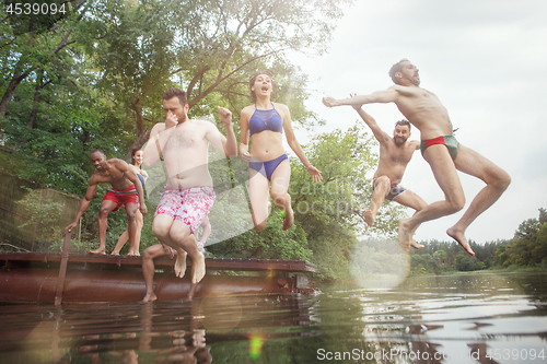 Image of Enjoying river party with friends. Group of beautiful happy young people at the river together