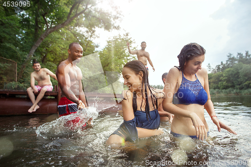 Image of Enjoying river party with friends. Group of beautiful happy young people at the river together