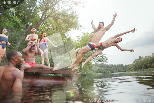 Image of Enjoying river party with friends. Group of beautiful happy young people at the river together