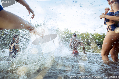 Image of Enjoying river party with friends. Group of beautiful happy young people at the river together