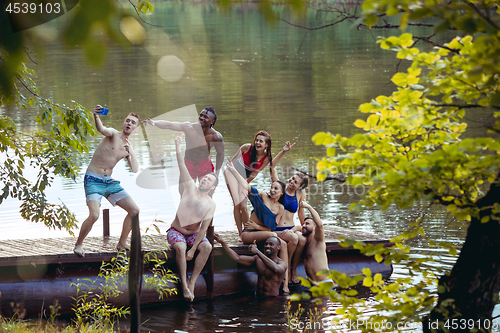 Image of Enjoying river party with friends. Group of beautiful happy young people at the river together