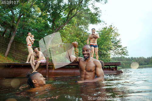 Image of Enjoying river party with friends. Group of beautiful happy young people at the river together