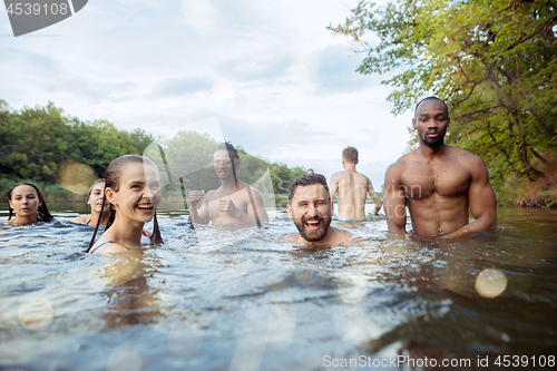 Image of Enjoying river party with friends. Group of beautiful happy young people at the river together