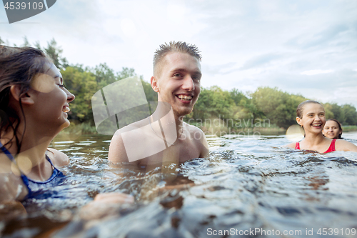 Image of Enjoying river party with friends. Group of beautiful happy young people at the river together