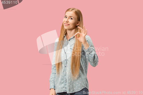 Image of The happy business woman standing and smiling against pink background.