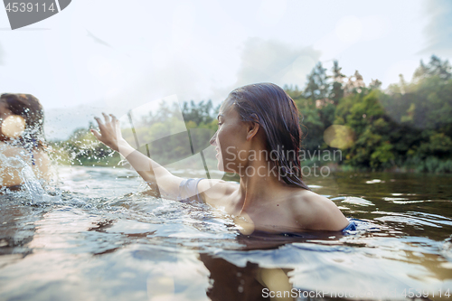 Image of Enjoying river party with friends. Group of beautiful happy young people at the river together