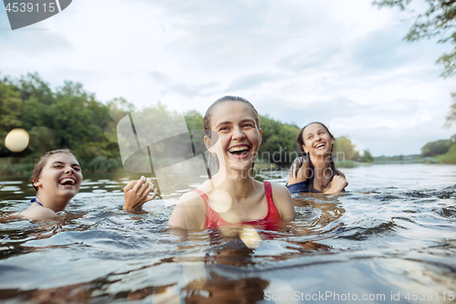 Image of Enjoying river party with friends. Group of beautiful happy young people at the river together