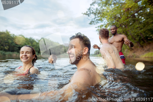 Image of Enjoying river party with friends. Group of beautiful happy young people at the river together