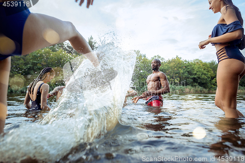 Image of Enjoying river party with friends. Group of beautiful happy young people at the river together