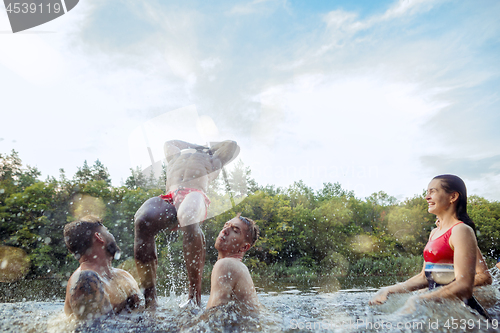 Image of Enjoying river party with friends. Group of beautiful happy young people at the river together