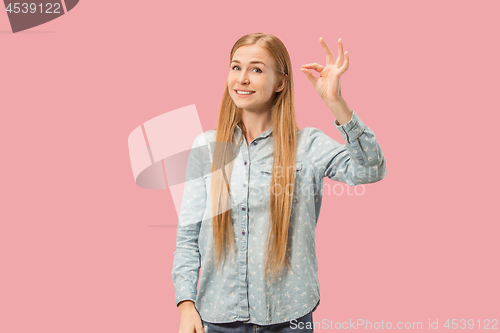 Image of The happy business woman standing and smiling against pink background.