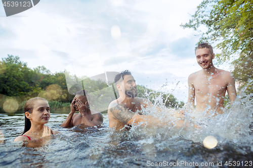 Image of Enjoying river party with friends. Group of beautiful happy young people at the river together