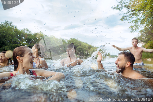 Image of Enjoying river party with friends. Group of beautiful happy young people at the river together