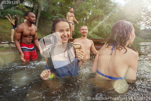 Image of Enjoying river party with friends. Group of beautiful happy young people at the river together