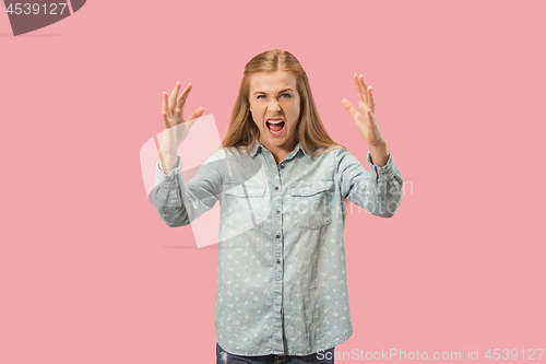 Image of Portrait of an angry woman looking at camera isolated on a pink background