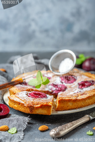 Image of Cut off a piece of plum pie with almonds.