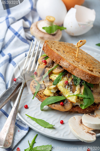 Image of Slices of toasted bread with egg and mushrooms.