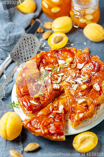 Image of Sliced caramelized tarte tatin pie with apricots.