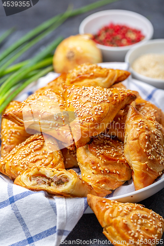 Image of Homemade samosas sprinkled with sesame seeds.