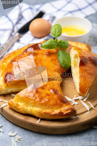 Image of Cut closed pie with cheese and egg (khachapuri).