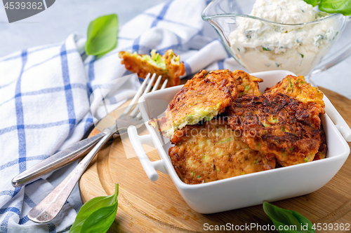 Image of Zucchini fritters with sour cream sauce.