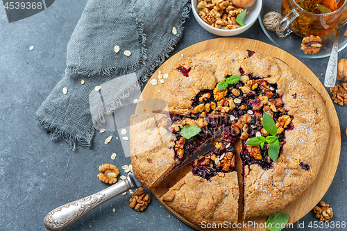 Image of Cut galette pie with oats, currants and walnuts.