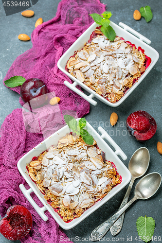 Image of Crumble with red plums and oat flakes.