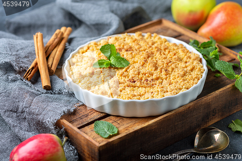 Image of  Apple crumble in white ceramic baking form.