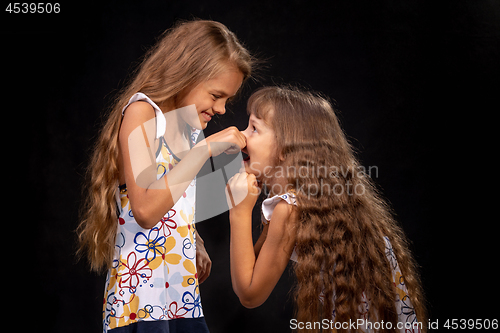 Image of Girl pinched a hand on the nose of another girl