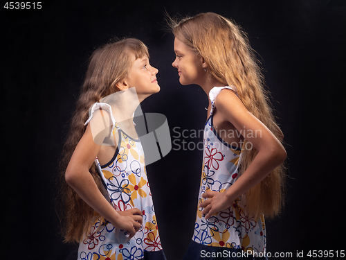 Image of Two girls are standing opposite each other and putting their hands on their sides are looking at each other.