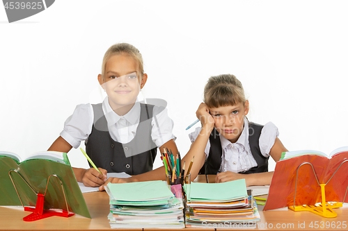 Image of Two schoolgirls at a desk, one funny, the other upset