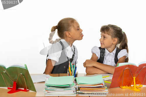 Image of Girl at her desk showed tongue to another girl