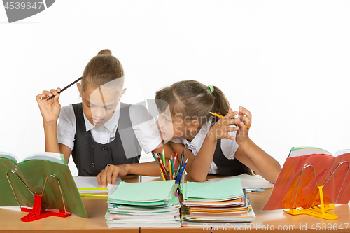 Image of One girl pestering another at a lesson at school