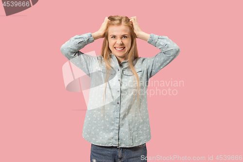 Image of Portrait of an angry woman looking at camera isolated on a pink background