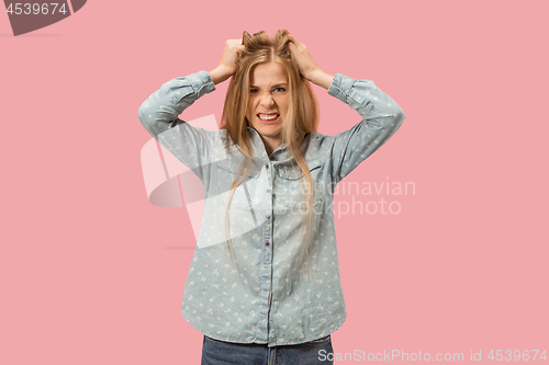 Image of Portrait of an angry woman looking at camera isolated on a pink background