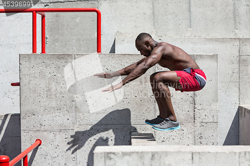 Image of Athlete doing exercises at stadium