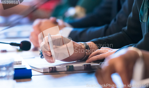 Image of close up of business people taking notes