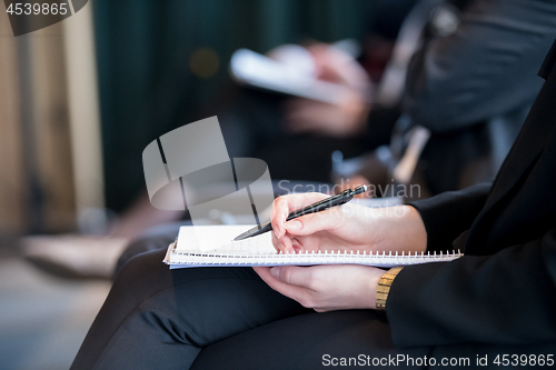 Image of close up of business people taking notes