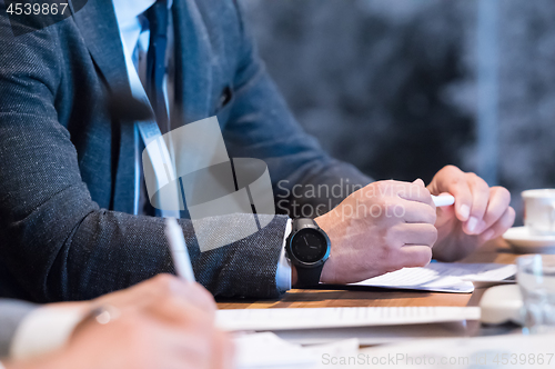 Image of close up of business people taking notes