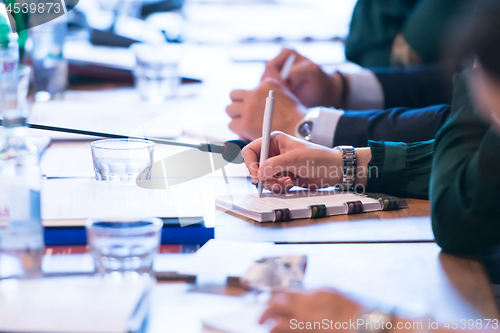 Image of close up of business people taking notes