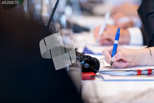 Image of close up of business people taking notes