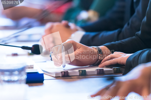 Image of close up of business people taking notes