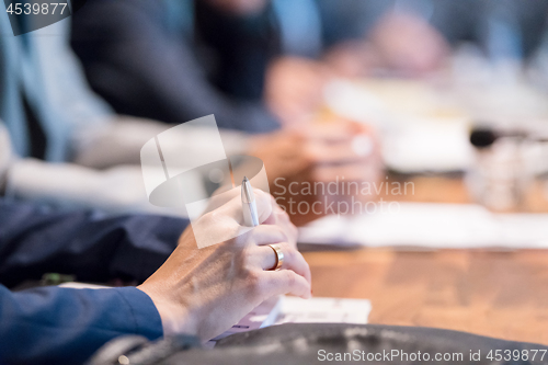 Image of close up of business people taking notes