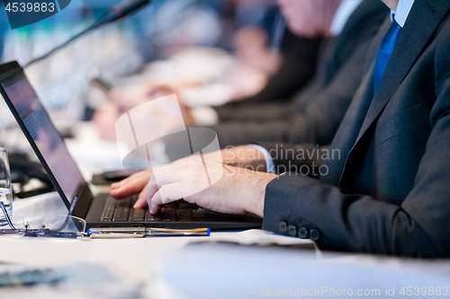 Image of close up of business people hands using laptop computer