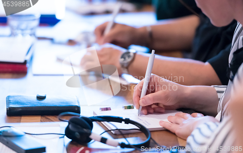 Image of close up of business people taking notes