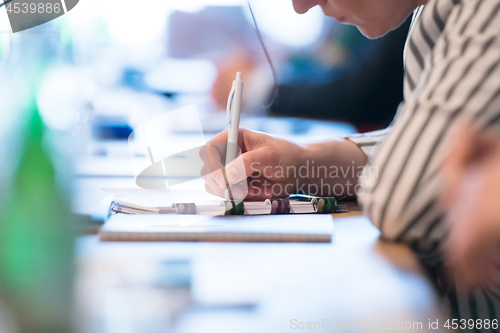 Image of close up of business people taking notes