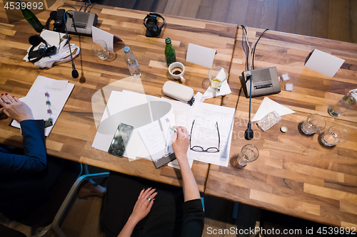 Image of top view of business people hands taking notes