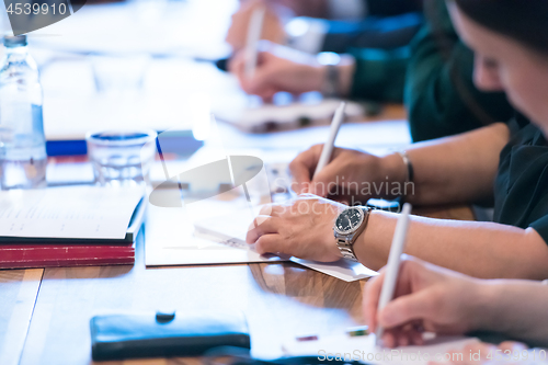 Image of close up of business people taking notes