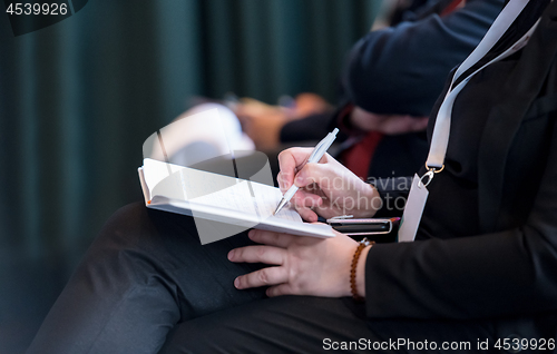 Image of close up of business people taking notes