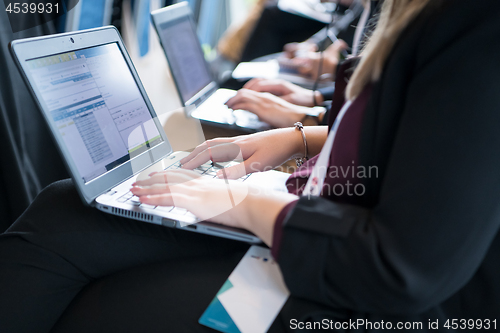 Image of close up of business people hands using laptop computer